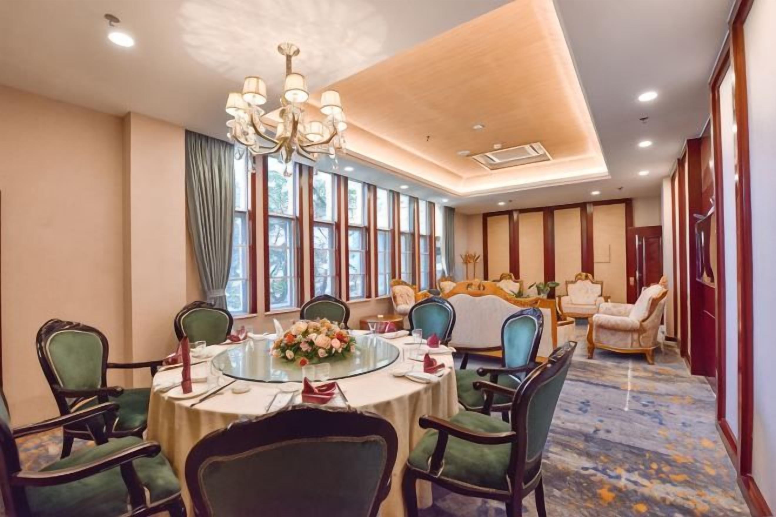A conference room with a round table, chairs, and a chandelier.