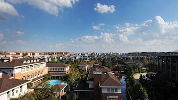 A residential area with multiple houses, a swimming pool, and a clear sky.