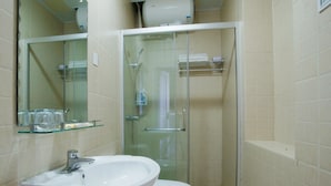 Ein Badezimmer mit Duschkabine, Waschbecken in Weiß und Toilette.
