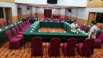 A conference room with a long table, chairs, and a person standing.