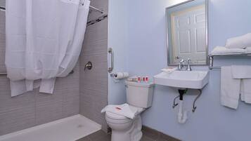 Un baño moderno con ducha, inodoro, lavabo y un perchero para toallas.