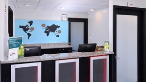 A reception desk with a world map, a sign about checking Choice Privileges, and a Dell computer.