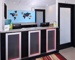 Bancada de recepção com um mapa-múndi, um aviso sobre o programa Choice Privileges e um computador Dell.