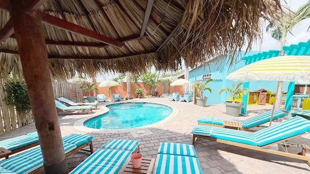 Un área de piscina con sillones de descanso y sombrillas.