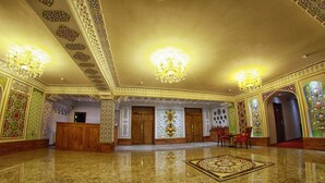 A spacious lobby with ornate ceiling designs, chandeliers, and a polished marble floor. - Emirhan (Samarkand)