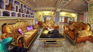 A luxurious room with ornate furniture, including two gold upholstered sofas and a black coffee table. - Emirhan (Samarkand)