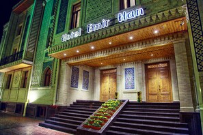 A hotel entrance with a grand staircase, ornate doors, and a sign reading "Hotel Emir Han".