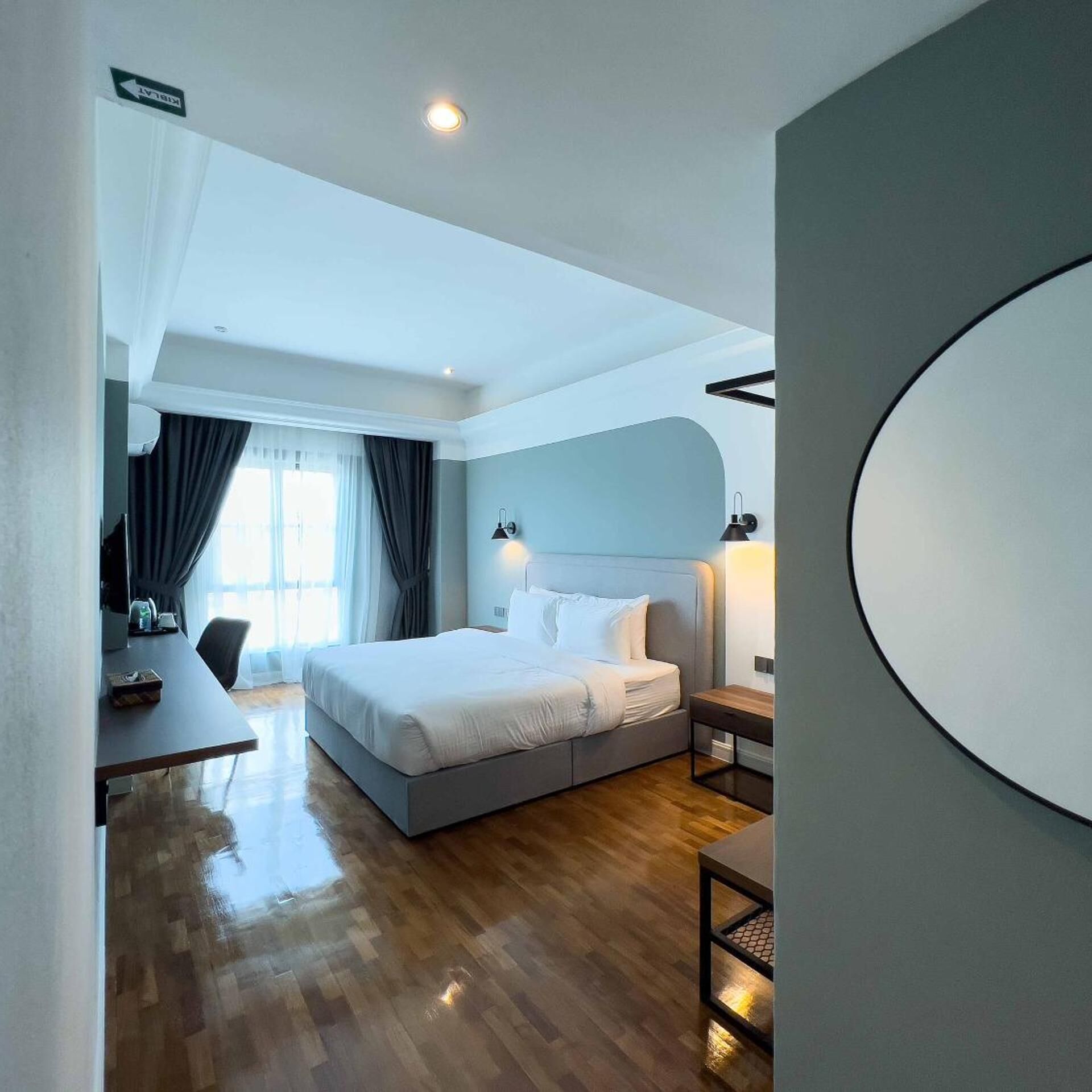 Una camera d'albergo moderna con un letto grande, una scrivania e vista all'esterno.