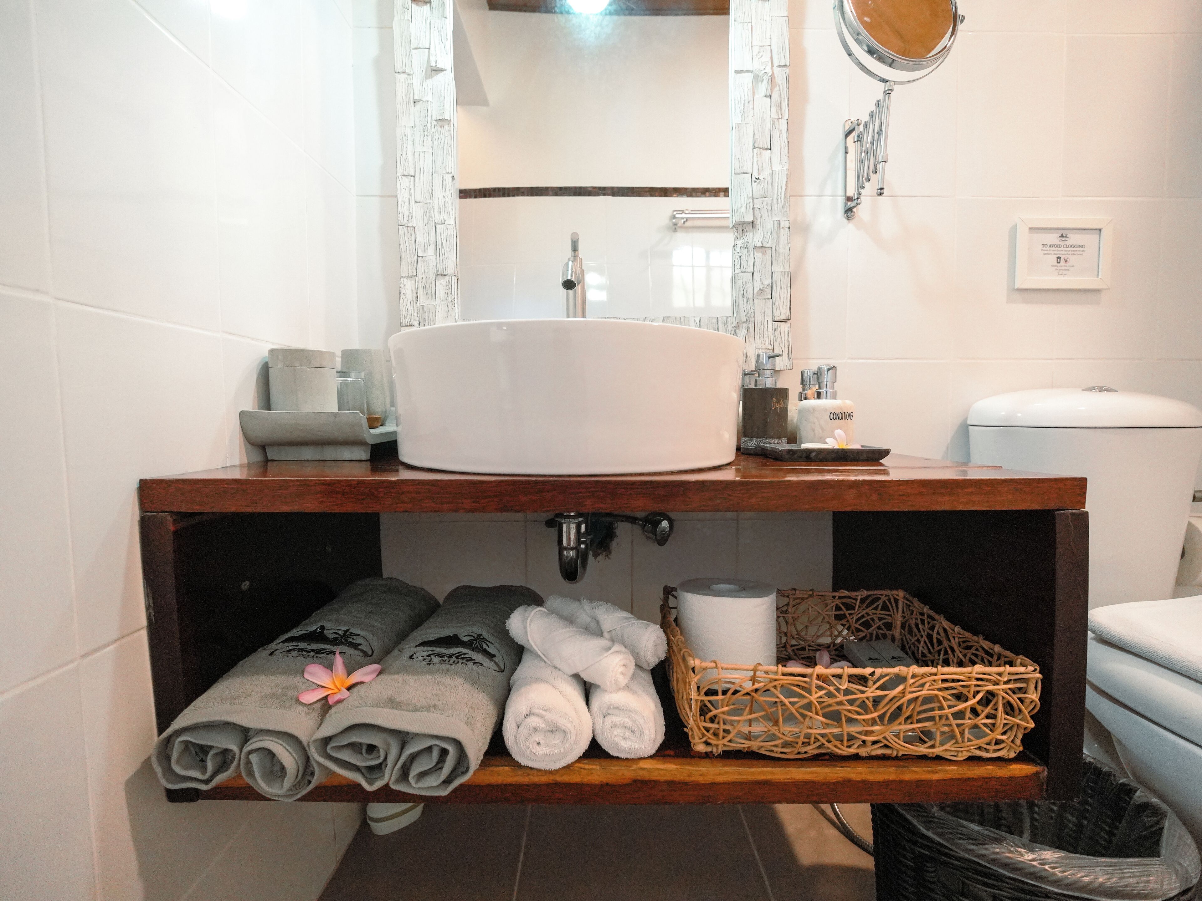 A bathroom with a white sink, mirror, and towel rack.