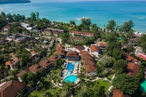 An aerial view of a resort with multiple buildings, a swimming pool, and a view of the ocean. - The Leaf Oceanside by Katathani (Takua Pa)