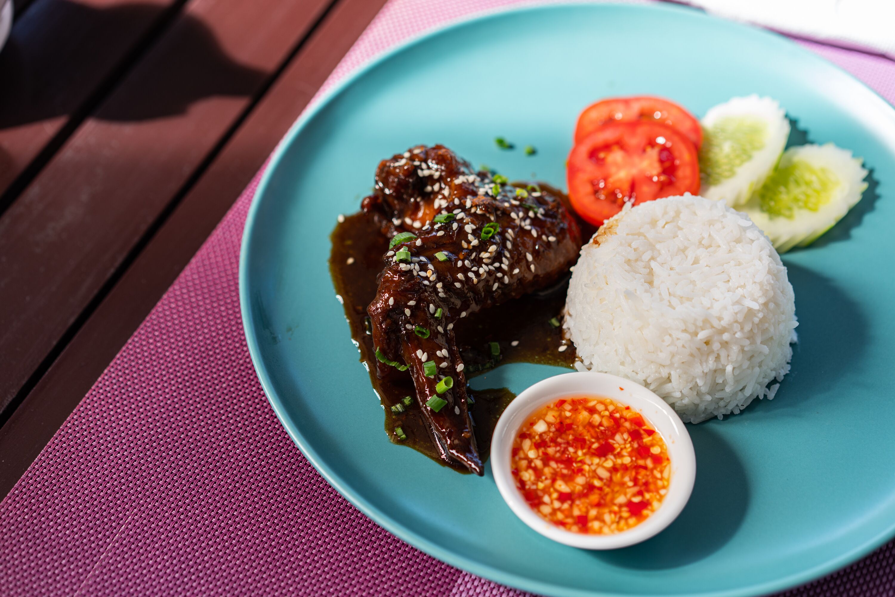 Un plato con carne, arroz y verduras sobre una mesa.