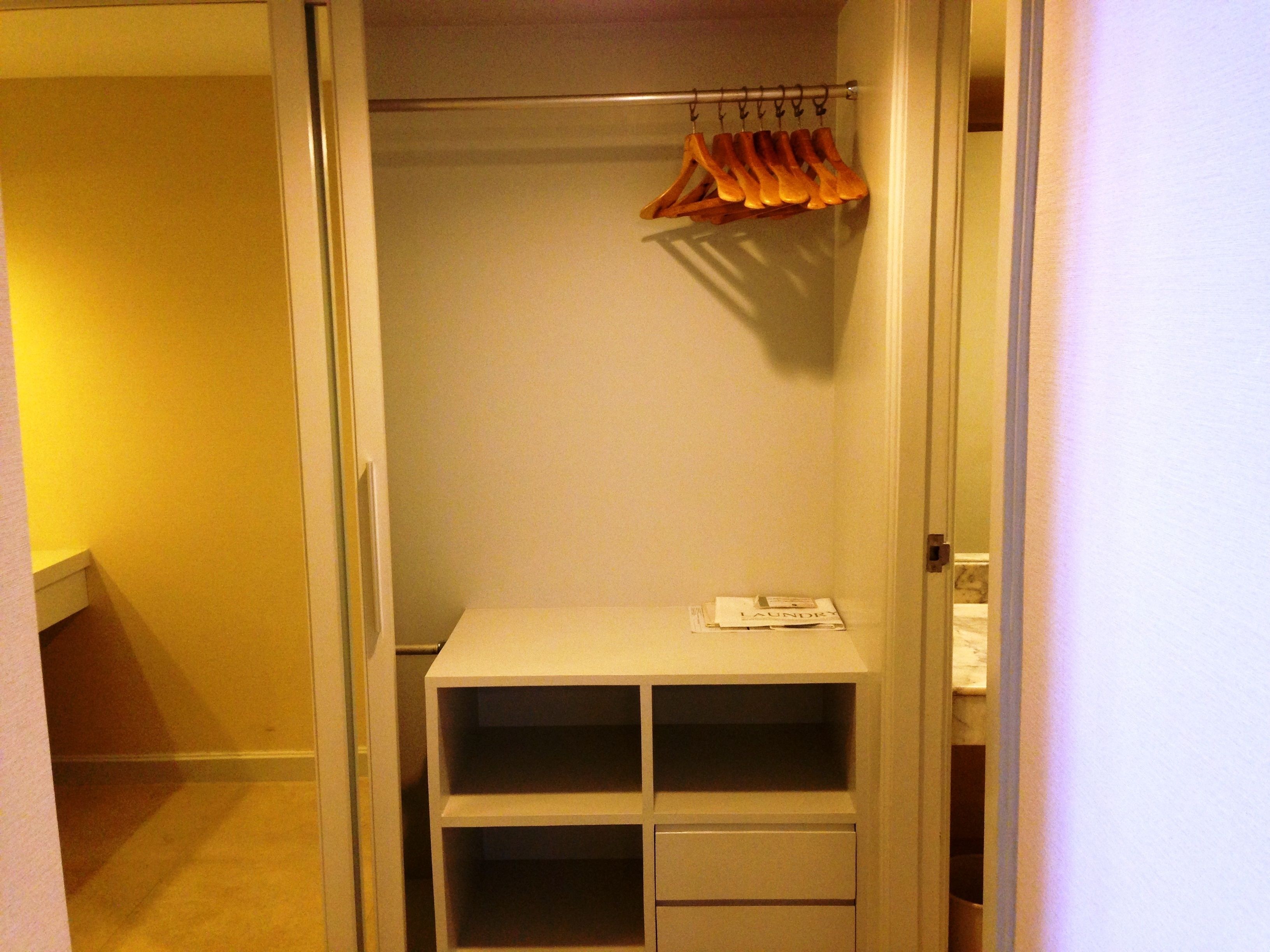 Un vestidor con un estante blanco, una percha para ropa y una puerta con interruptor de luz.