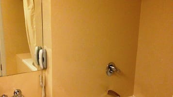 A bathroom with a sink, mirror, shower, and bathtub.