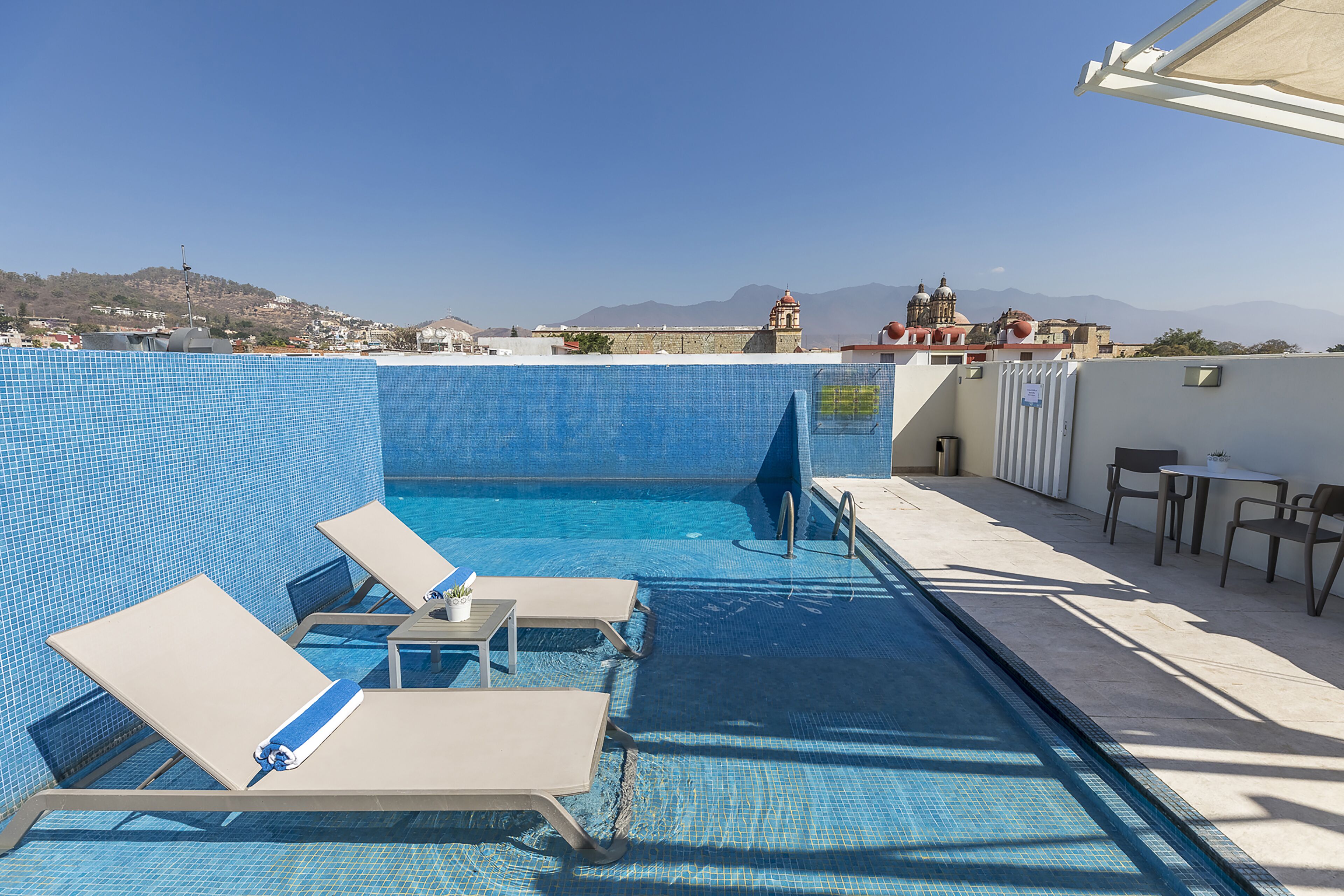 Alberca al aire libre, sombrillas en la alberca y camastros 