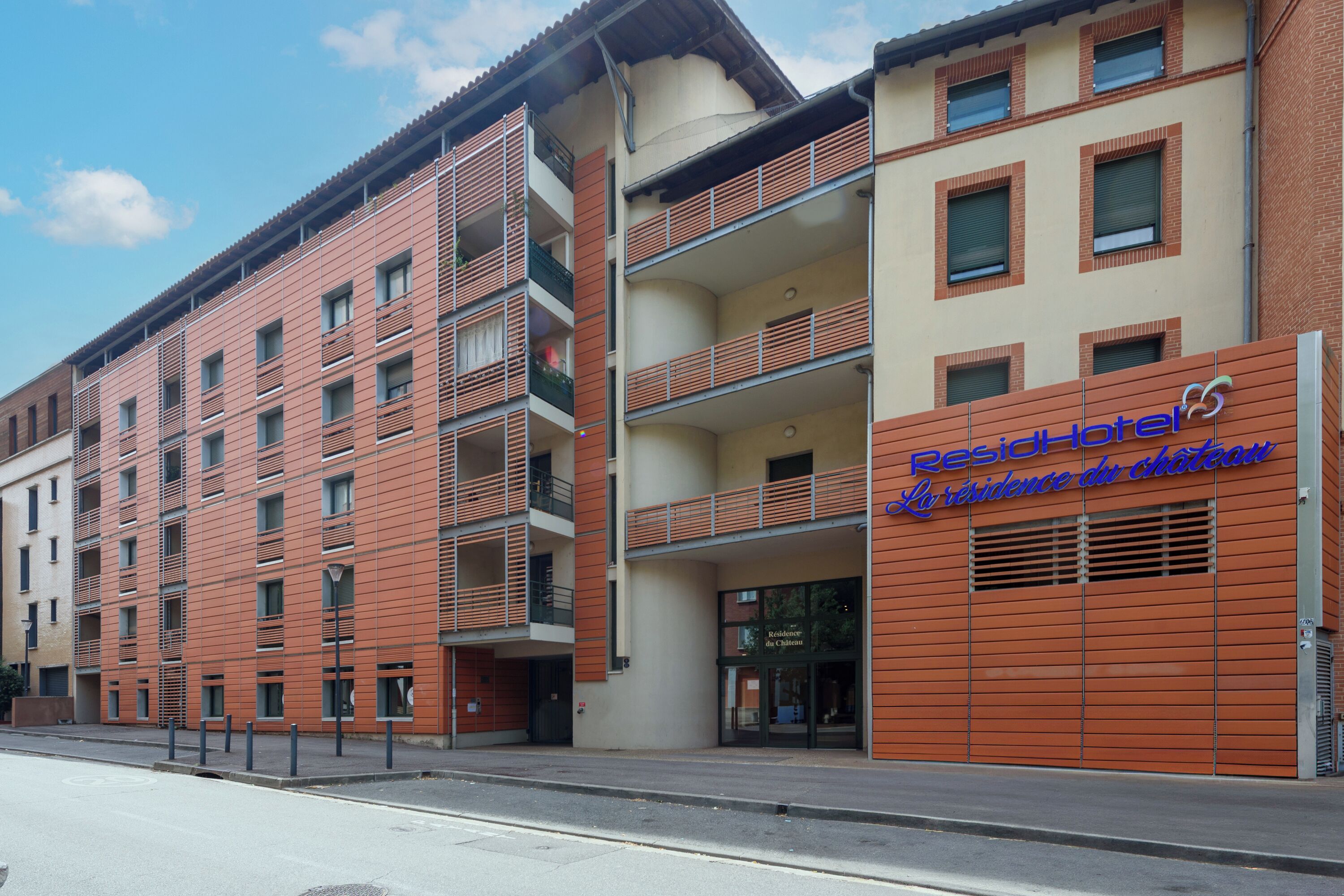 Un hôtel à l’architecture moderne, doté de nombreux balcons et d’une enseigne indiquant qu’il s’agit d’une résidence hôtelière.