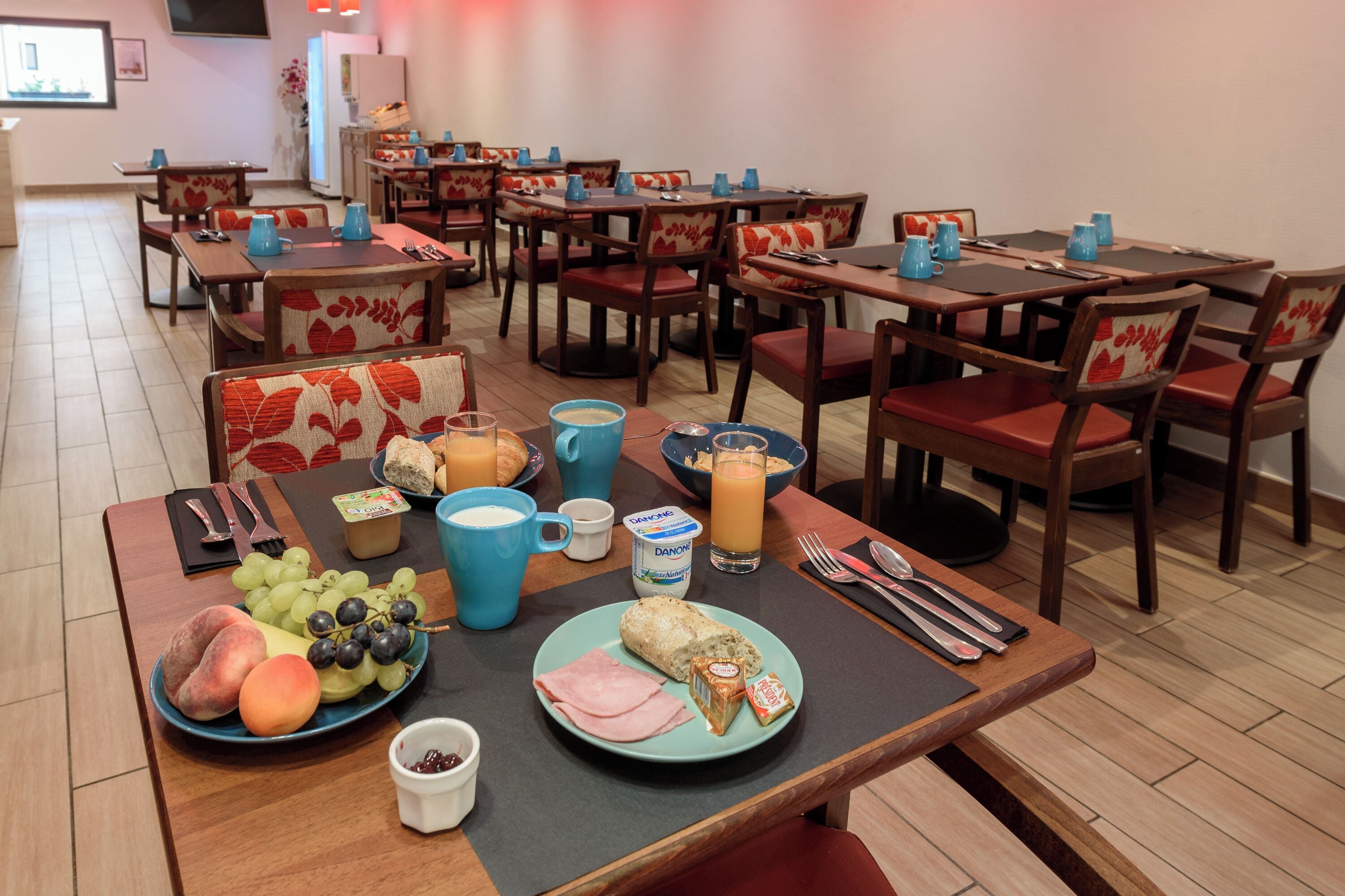 A breakfast setting with tables, chairs, and a variety of food and drink items.