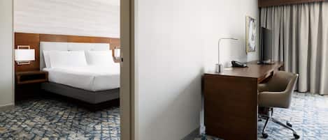 Una habitación de hotel con cama, escritorio, silla y televisor.
