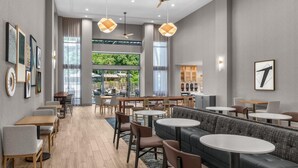 A modern dining area with multiple seating options including tables, booths, and a long counter.