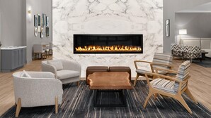 A modern living room with a fireplace, grey and brown furniture, and a marble wall.