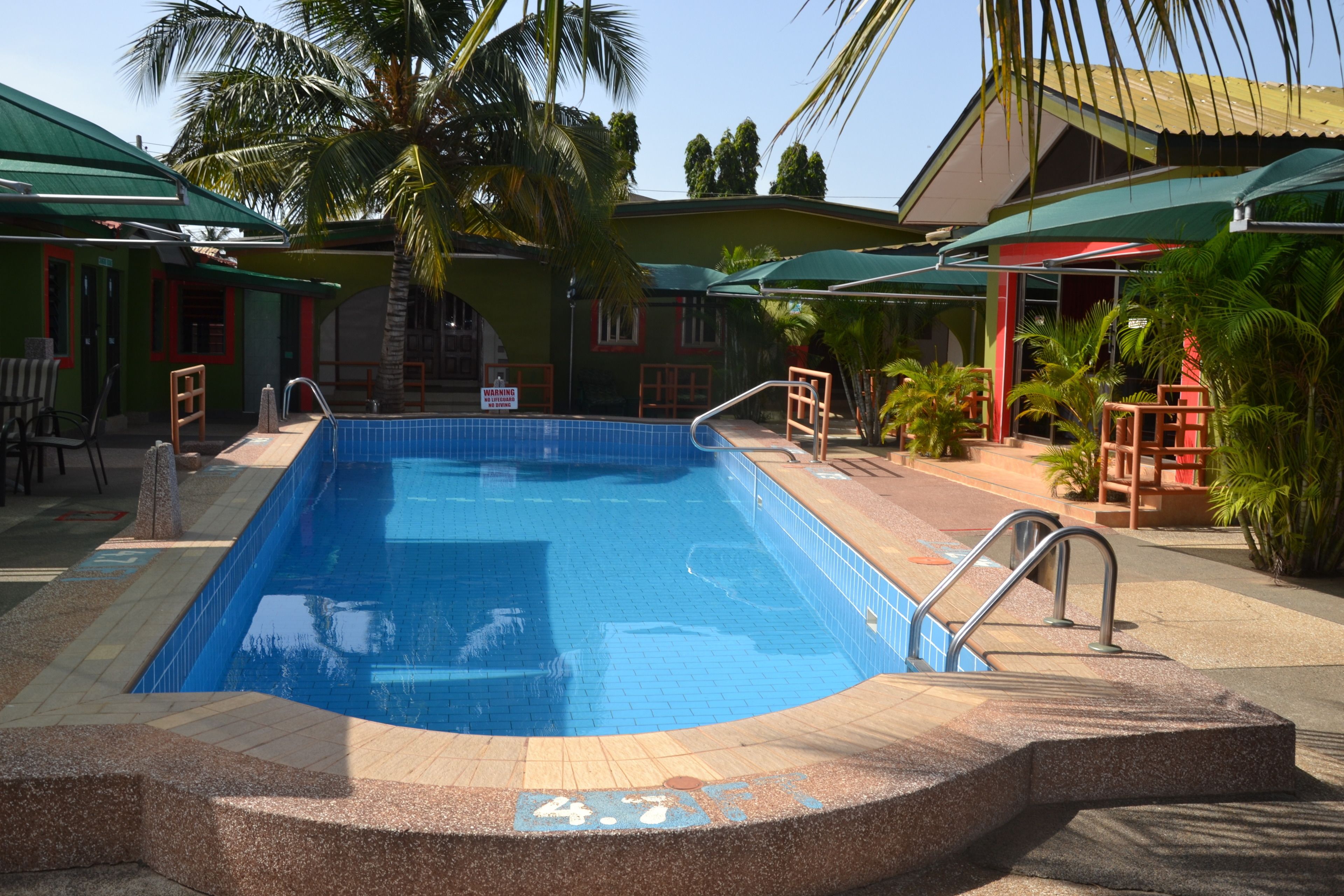 Una piscina al aire libre, sombrillas, tumbonas