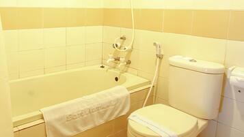A bathroom with a bathtub, toilet, and a towel hanging on the wall.