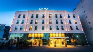 A hotel with a modern facade, large glass windows, and a well-lit entrance.