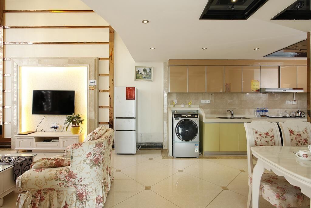 A modern apartment with a living room, dining area, kitchen, and a TV.
