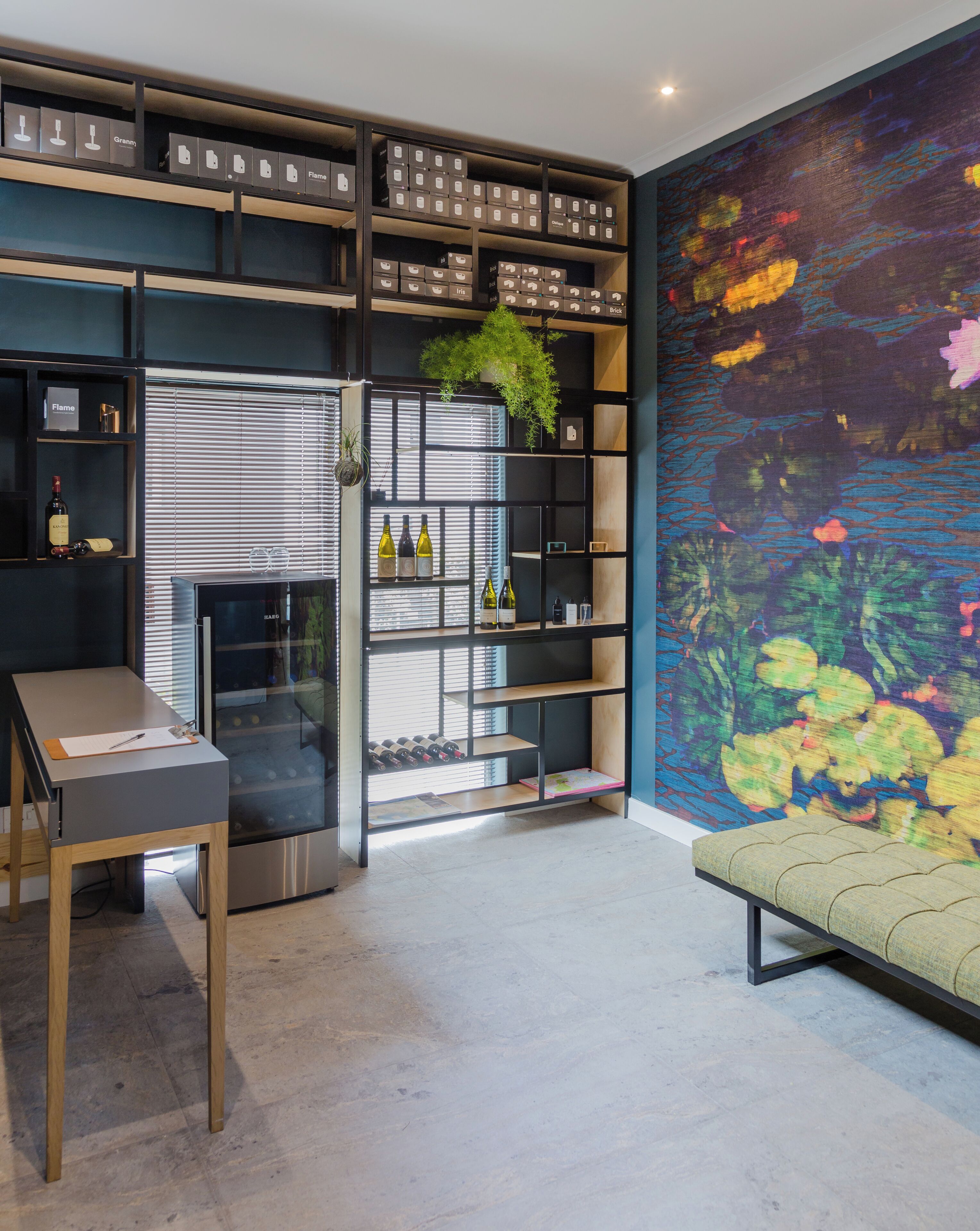 Een modern interieur met een wijnrek, een bankje en een groot abstract schilderij.