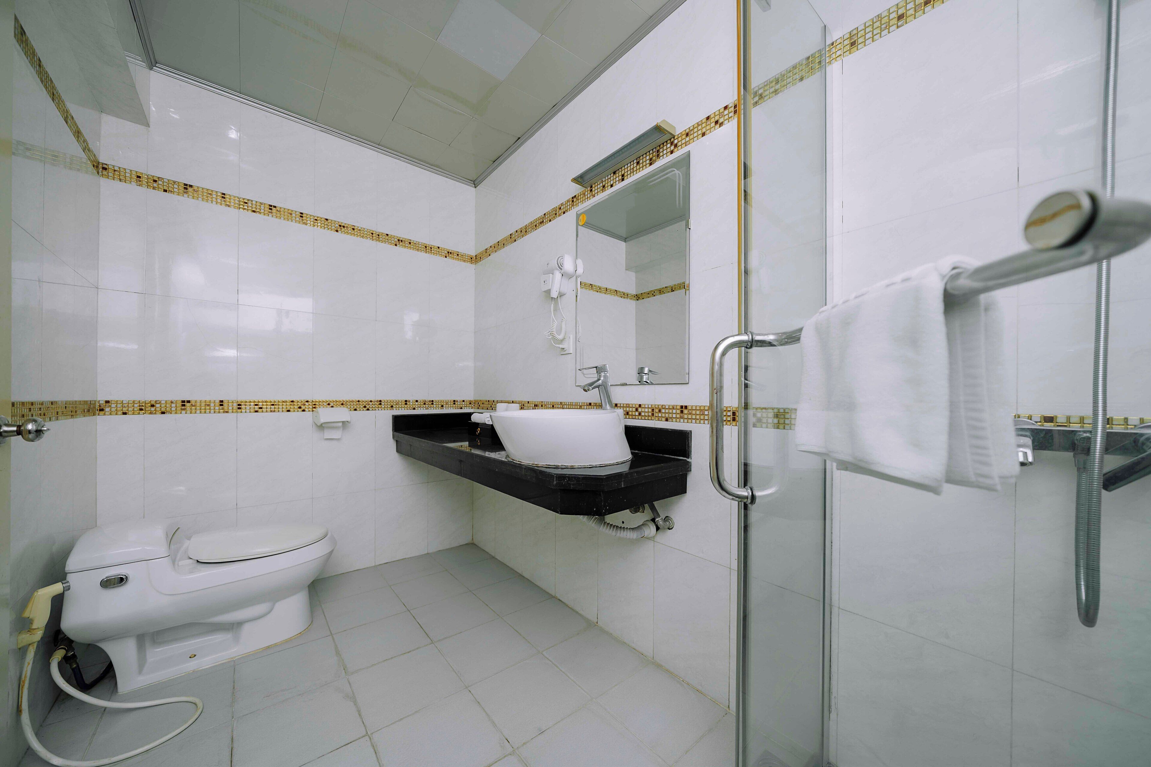A bathroom with a toilet, sink, and shower.