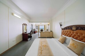A hotel room with a large bed, a wooden dresser, a desk with a chair, and a mirror on the wall. - Hoang Long Hotel - Hai Phong Center (Hai Phong)