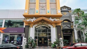Um hotel alto com design arquitetônico clássico, apresentando uma entrada imponente com colunas e fachada detalhada.