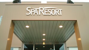 La entrada a un edificio con un cartel que dice 'Spa Resort'.