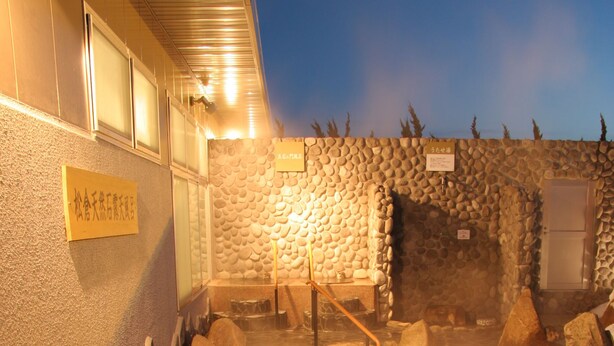 Un espacio de baño de piedra tradicional con un banco de madera y una pared de piedra.