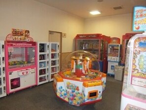 Een rij felgekleurde speelautomaten in een ruimte.