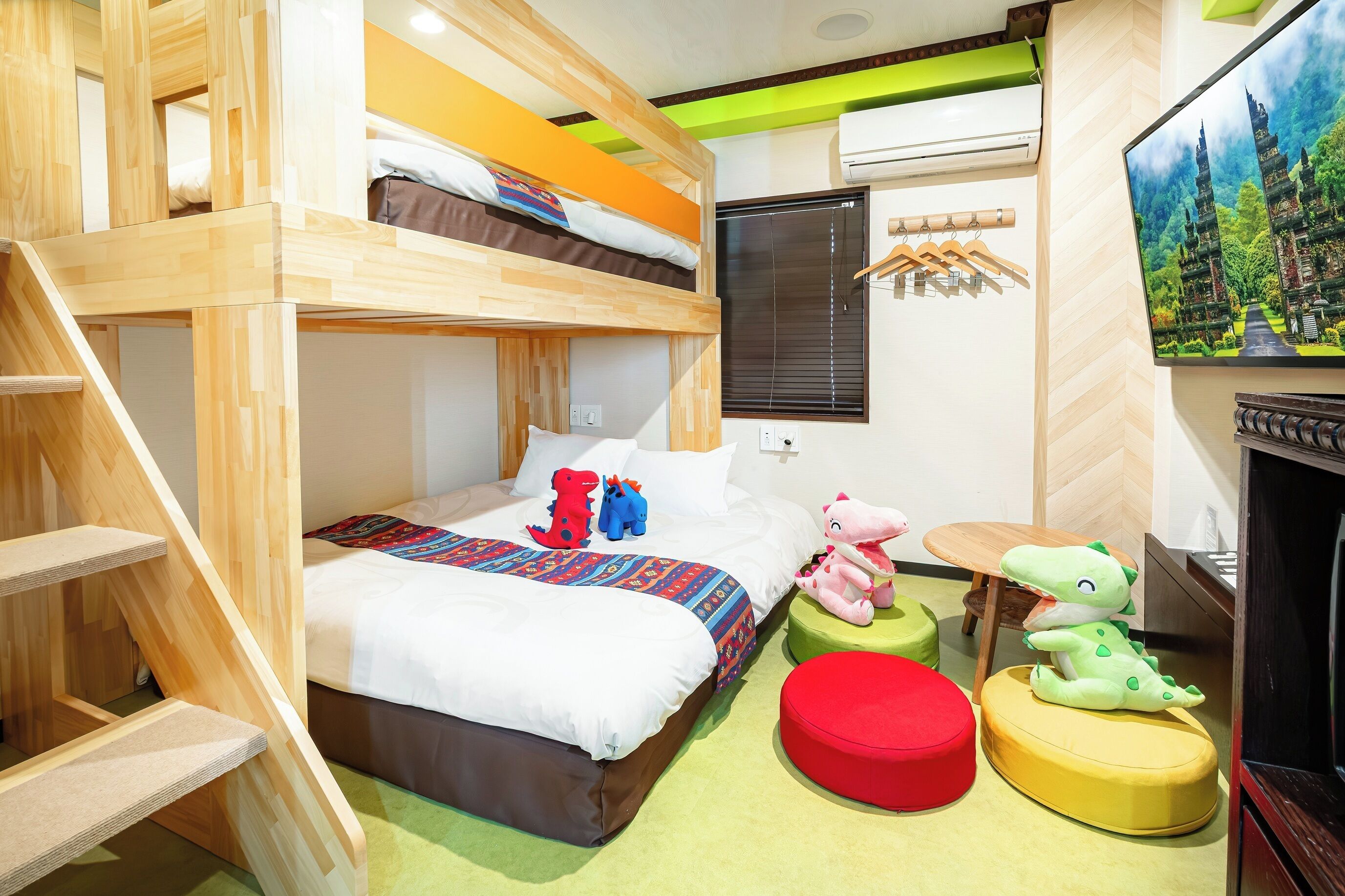 Ein Mehrbettzimmer mit Fernseher, Fenster und Treppe.