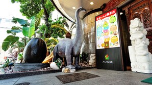 A dinosaur statue, a large stone sphere, and a traditional Chinese lion statue in an indoor setting with a tiled floor and decorative ceiling. - Anda no Mori Osaka Tennoji Tower (Osaka)
