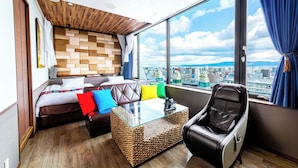 A modern hotel room with a bed, a glass-top coffee table, a massage chair, and a large window offering a city view. - Anda no Mori Osaka Tennoji Tower (Osaka)