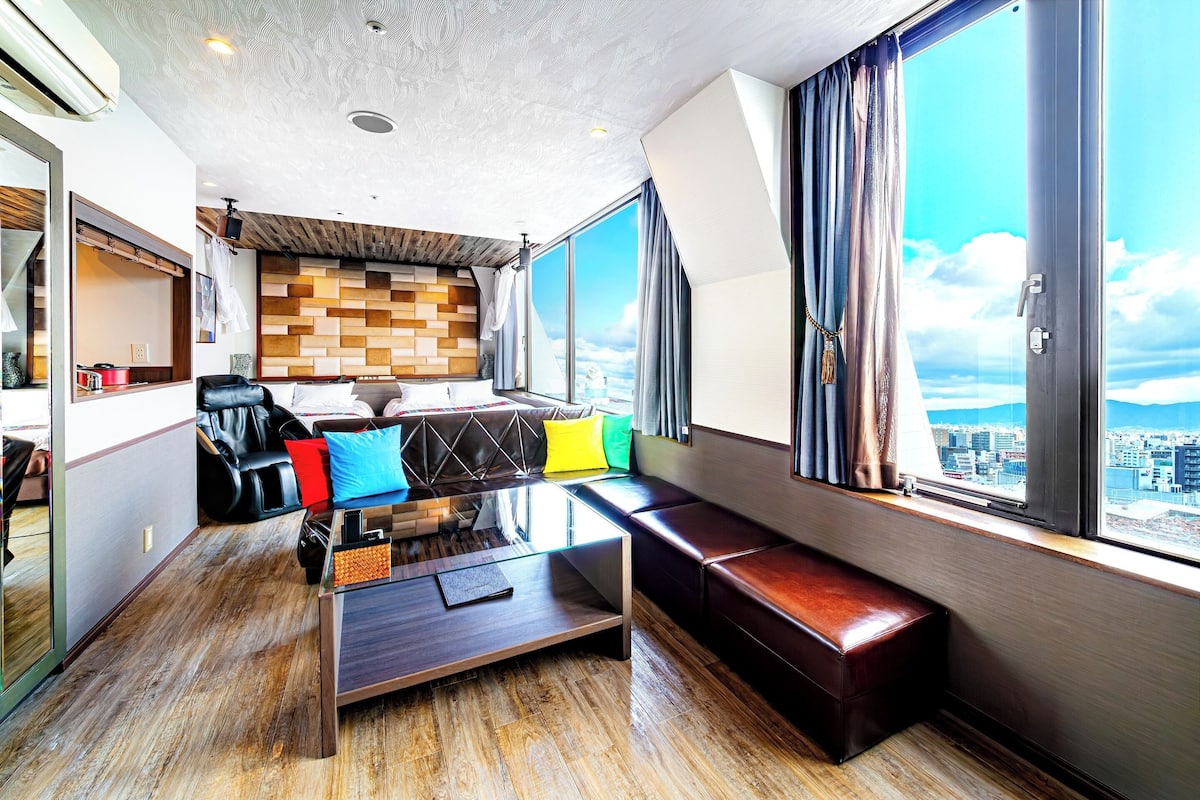 Een moderne hotelkamer met uitzicht op de stad, een bank, een salontafel en een eethoek.