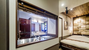 A compact hotel room with a large mirror, a modern sink, a bed, and a wooden headboard. - Anda no Mori Osaka Tennoji Tower (Osaka)