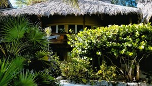 A thatched-roof structure surrounded by lush greenery. - Xanadu Island Resort (San Pedro)