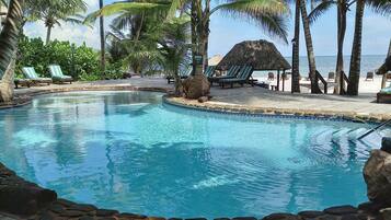 Een buitenzwembad, ligstoelen bij het zwembad