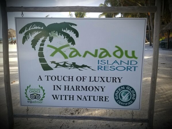 Letrero de Xanadu Island Resort, destacando su lujo, armonía con la naturaleza y certificación Green Globe.