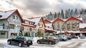 Ein Hotel mit mehreren Gebäuden, jedes mit rotem Dach und Balkonen. Vorne sind mehrere Autos geparkt.