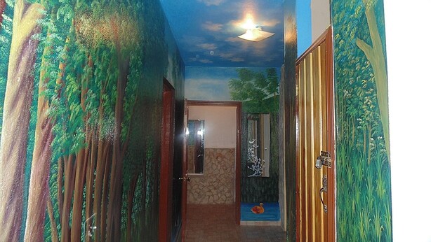 A hallway with a mural of trees and a small pool with a duck. - Metro Residences Hotel (Cap-Haitien)