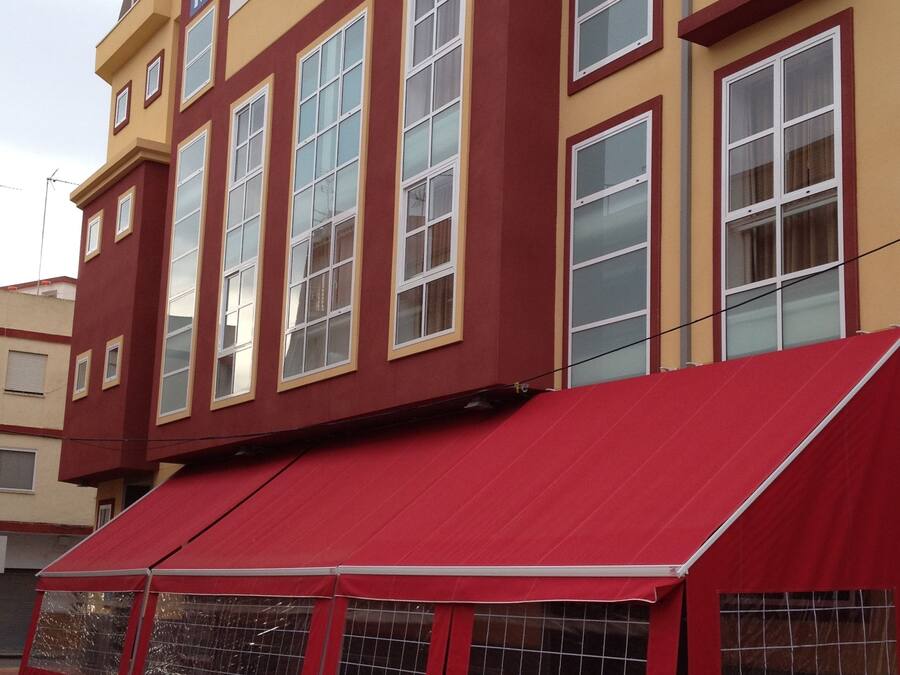 A building with a red awning and multiple windows.