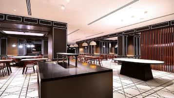 Un restaurant moderne doté d’un bar central, de plusieurs tables et d’un sol à motifs.