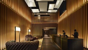 A modern lobby with a central seating area, a reception desk, and a staircase leading to an upper level. - G Hotel Kelawai (George Town)