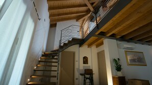 Una escalera de madera con barandilla de metal que sube a un segundo piso.