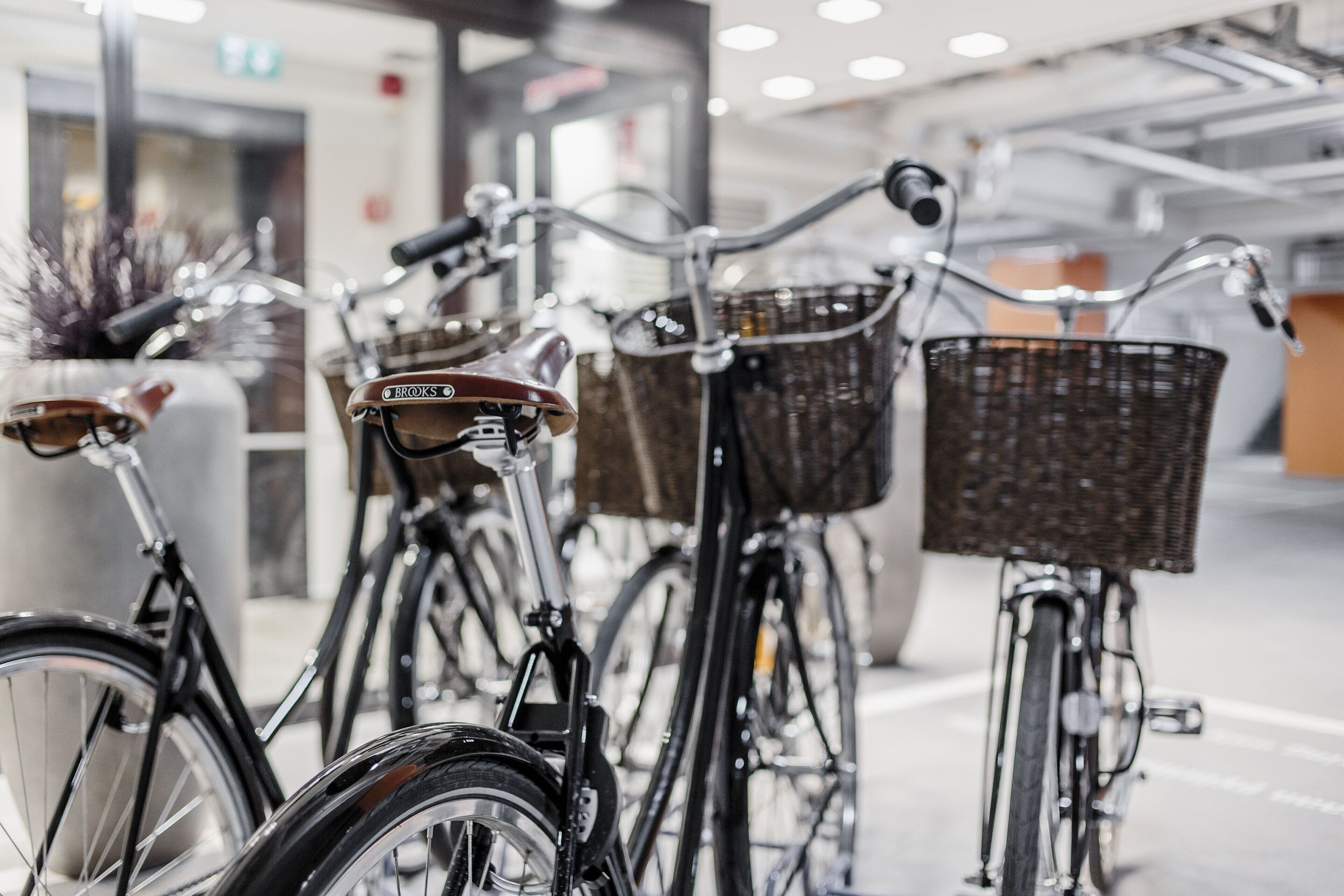 Biciclette parcheggiate in fila con cesti anteriori.