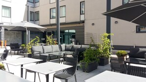 Un espace extérieur aménagé avec des tables, des chaises, un canapé et des plantes en pot.